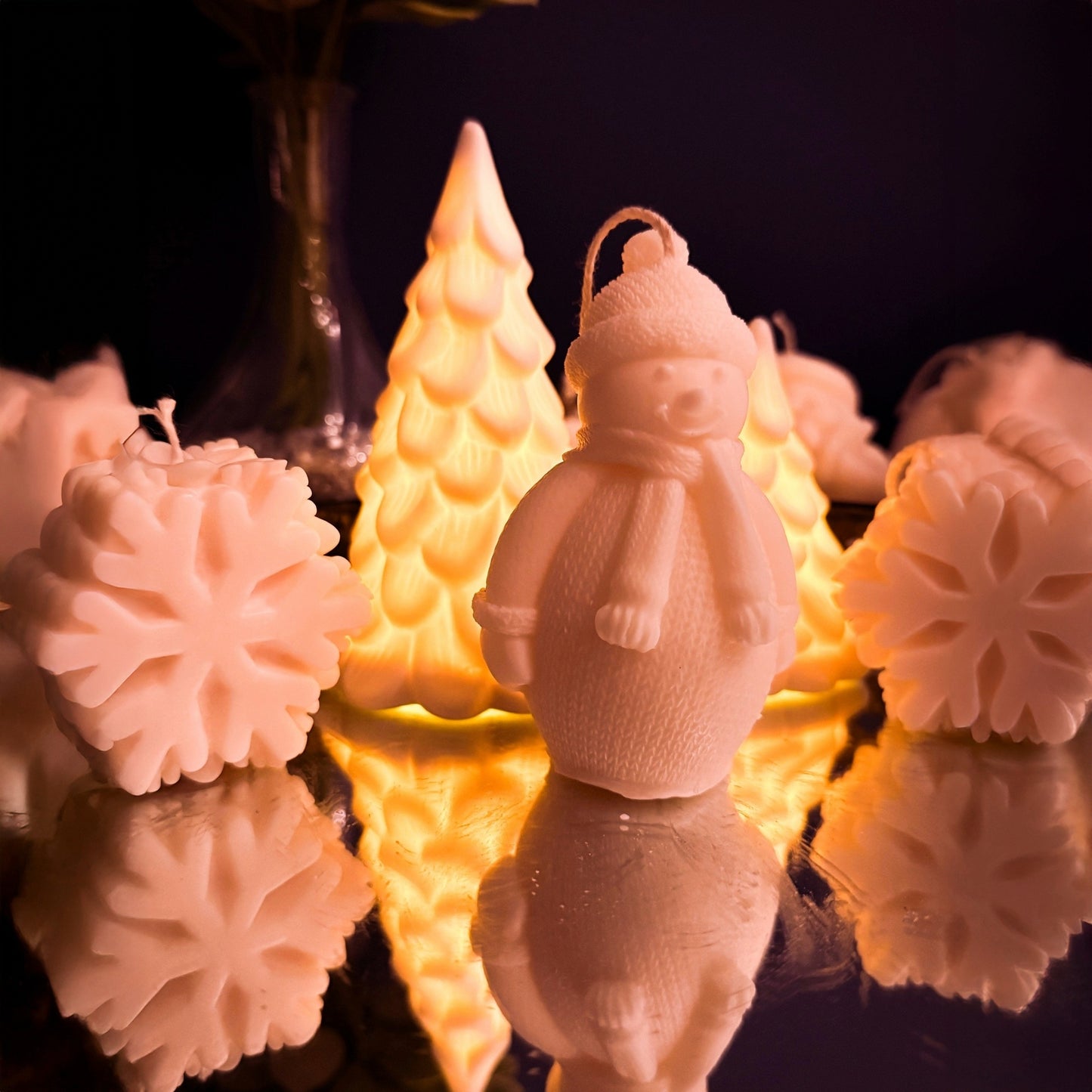 Large artisan snowman-shaped soy wax candle viewed from the left, detailed winter clothing texture, festive decorative candle for Christmas and winter interiors.