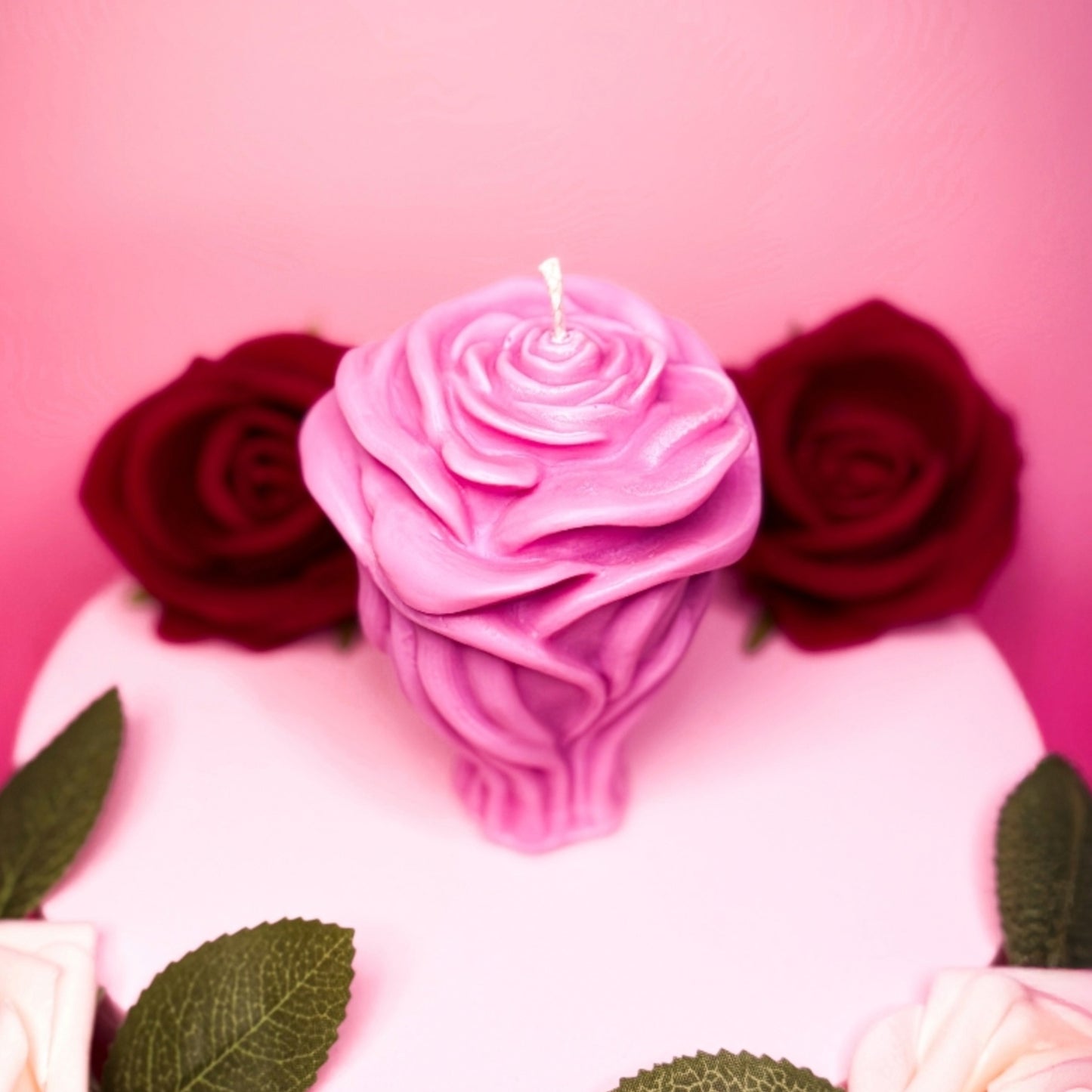 Pink handmade rose candle in soy wax styled for Valentine’s Day.
