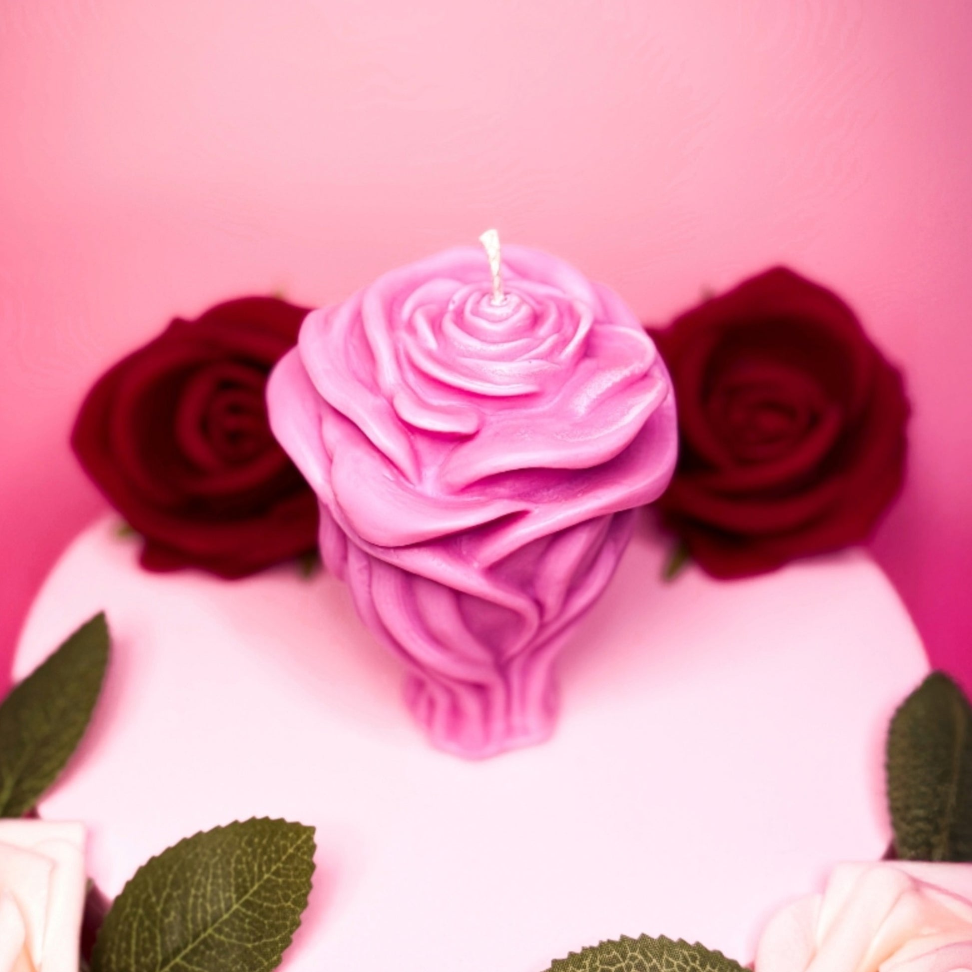 Pink handmade rose candle in soy wax styled for Valentine’s Day.