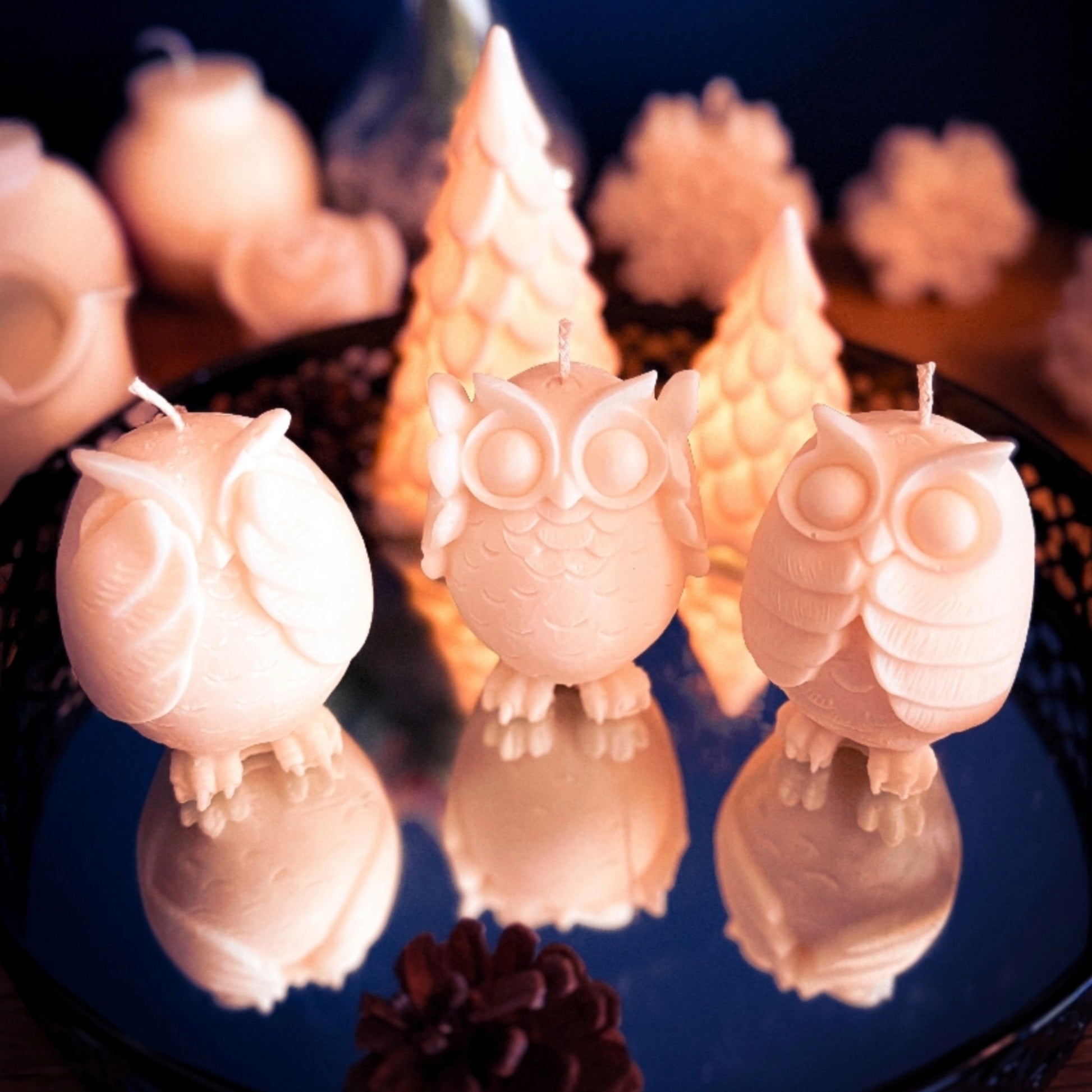 Handmade owl trio candles in soy wax, three small decorative owl candles displayed together on a mirrored tray with warm winter lighting.