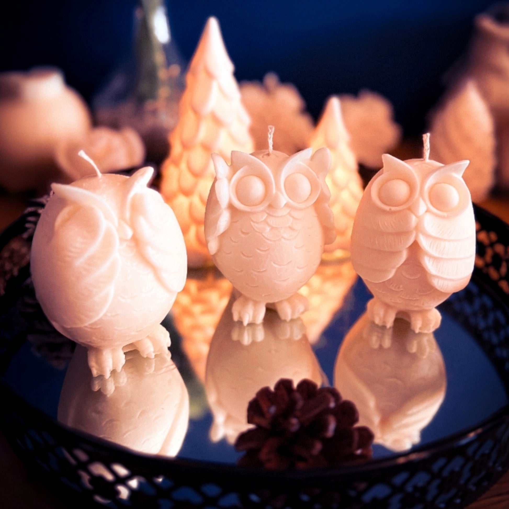 Three handmade owl candles in soy wax shown from the side, decorative owl trio with detailed feathers and winter-inspired styling.