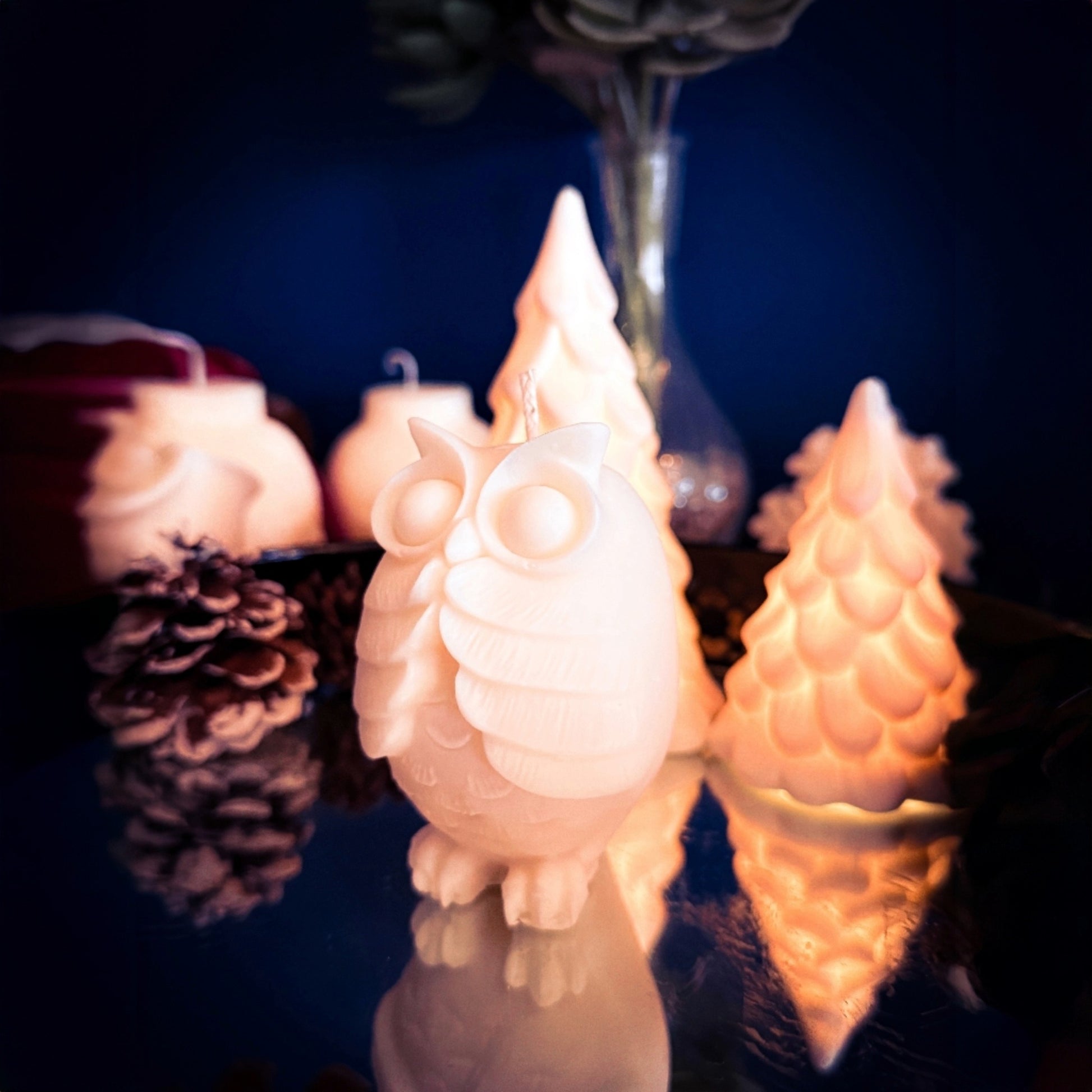 The Shocked Owl decorative soy candle styled with warm lighting and winter decor.