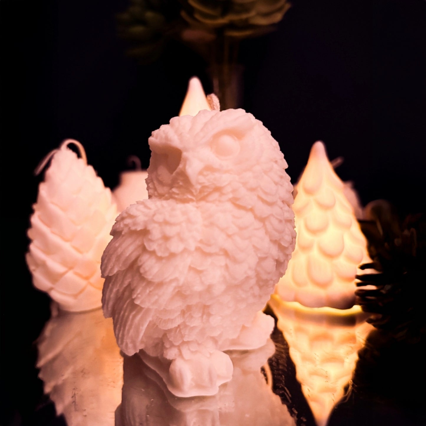 Close-up of handcrafted snowy owl candle in soy wax showing detailed feathers and winter inspired design.
